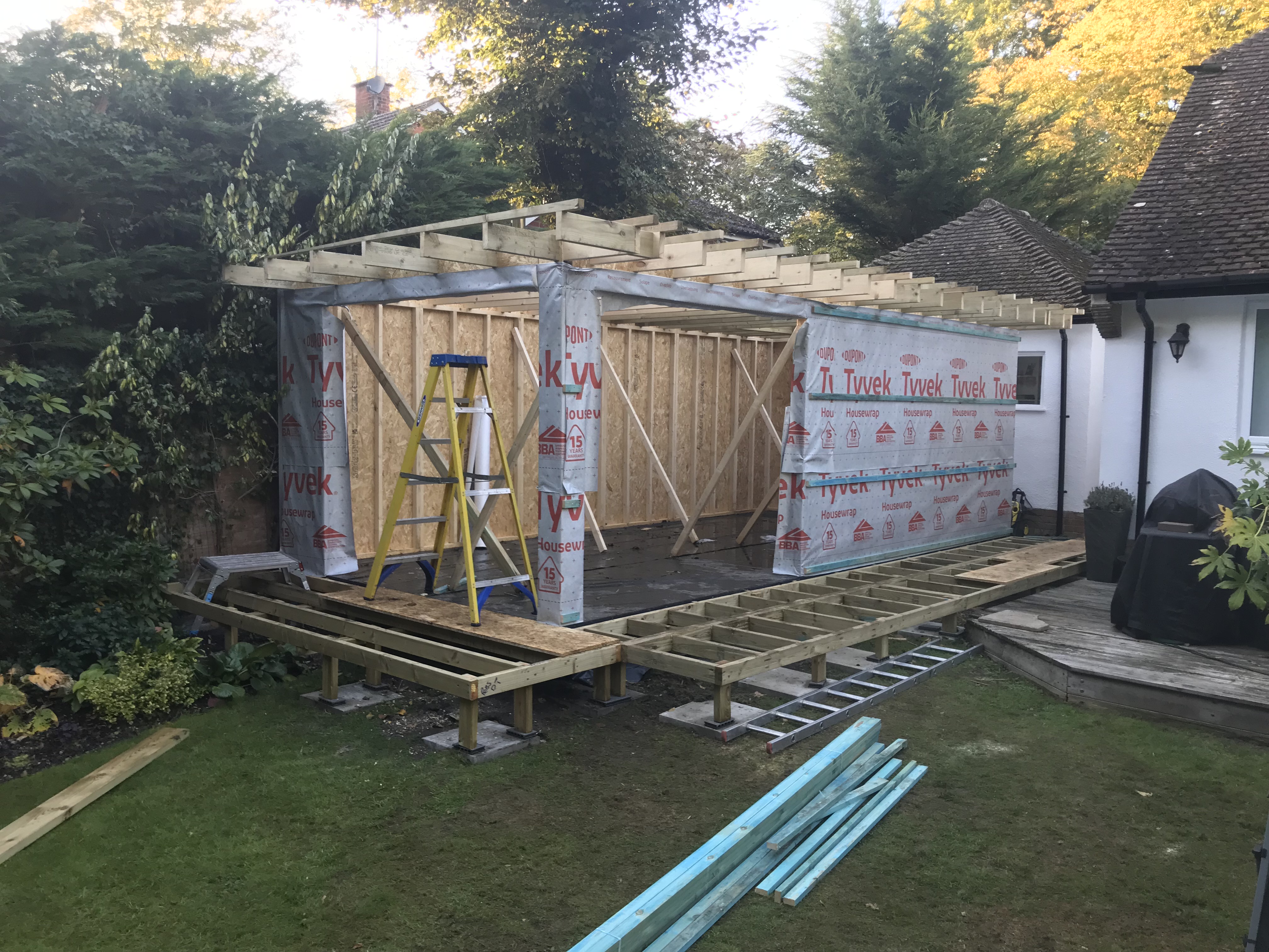 A wooden deck being constructed on the exterior of a house.