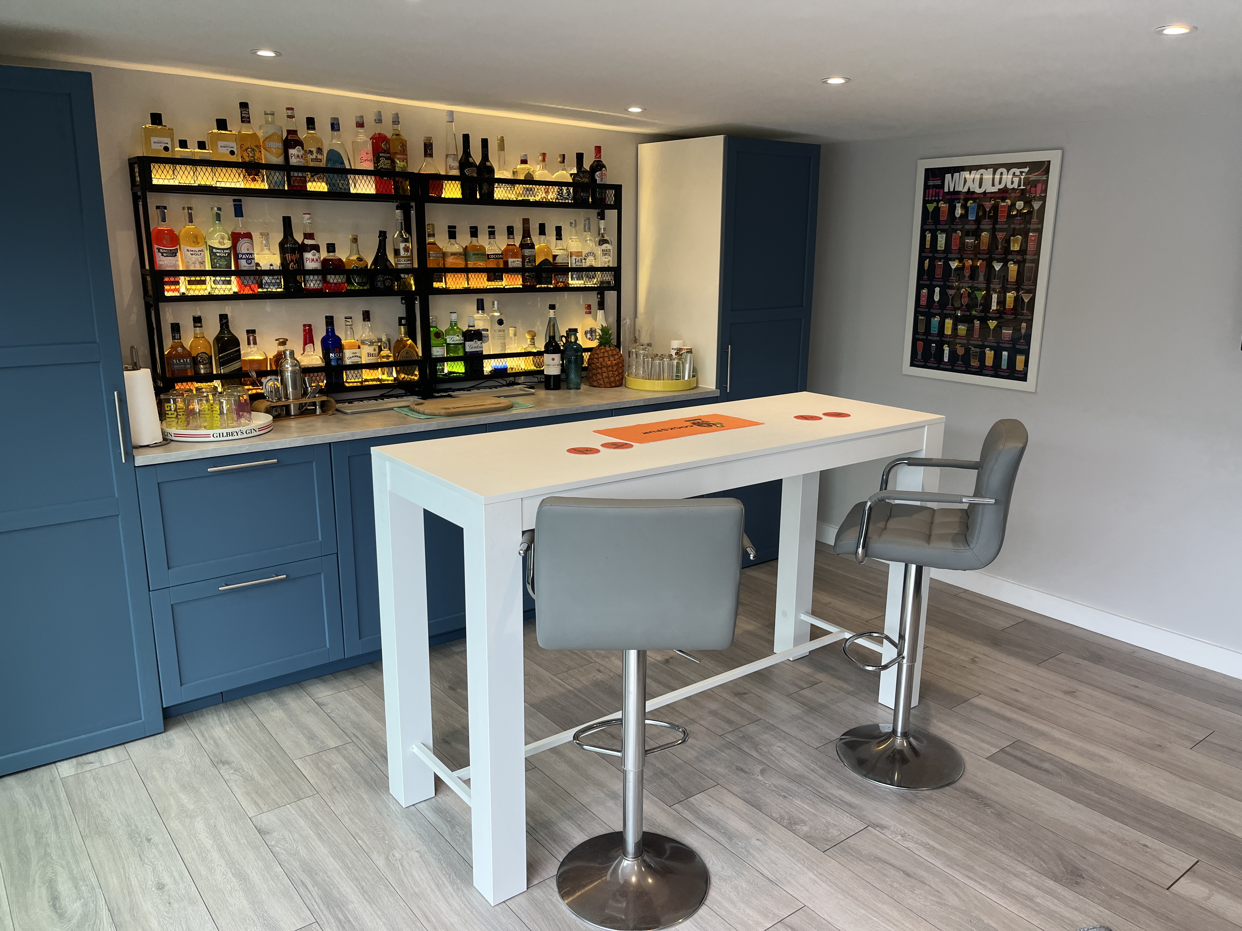 Cosy wooden garden office with large glass sliding doors, warm interior lighting, and a charming gravel pathway, nestled in a lush garden setting.